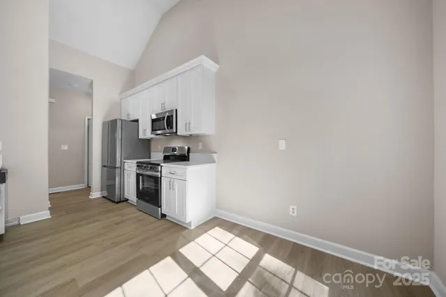 a kitchen with granite countertop a refrigerator and a stove top oven