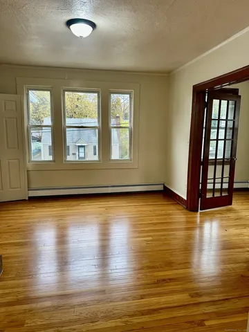 an empty room with wooden floor and windows