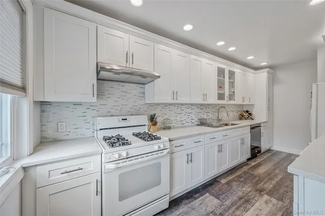 a kitchen with granite countertop white cabinets and white appliances