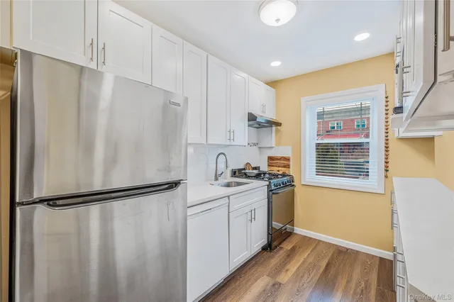 a kitchen with stainless steel appliances a refrigerator and a stove top oven
