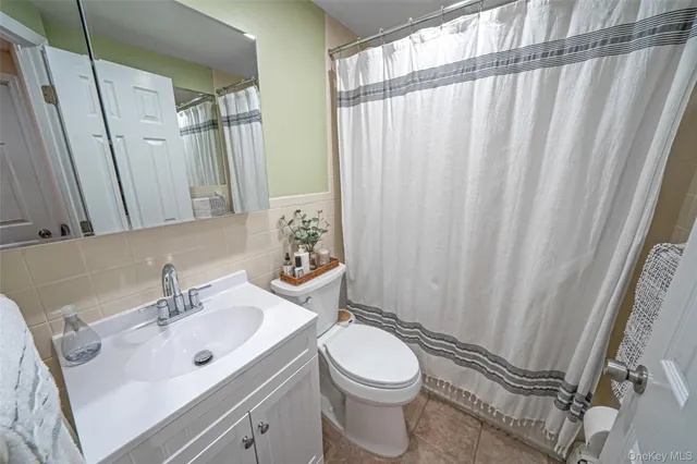 a bathroom with a sink a toilet and shower curtain