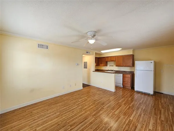 a kitchen with a refrigerator a sink and dishwasher with wooden floor