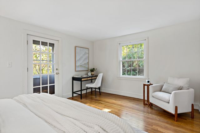 a bedroom with a bed and a couch next to a window