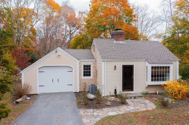a view of a house with a yard and large tree