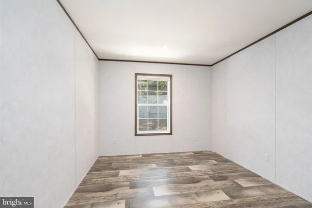a view of a big room with wooden floor and windows