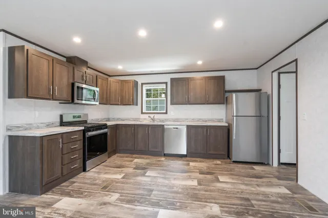 a kitchen with stainless steel appliances granite countertop a refrigerator and a stove top oven