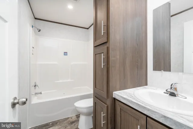 a bathroom with a sink toilet vanity and shower