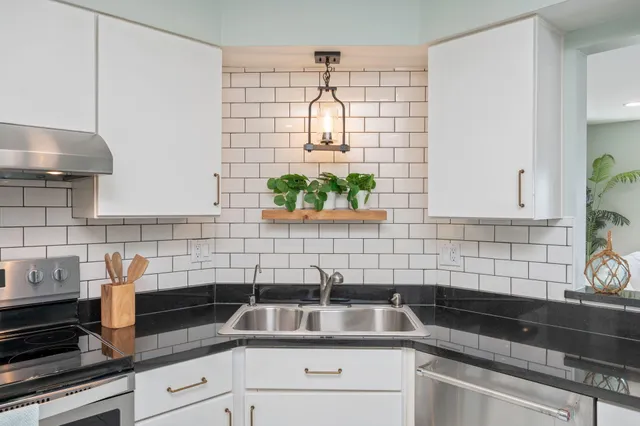 a kitchen with stainless steel appliances granite countertop a refrigerator and a sink