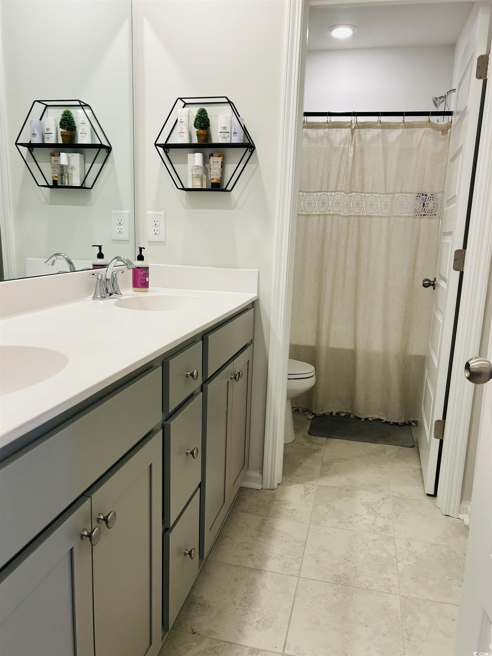 609 Shortleaf Path Myrtle Beach, SC 29577 - Photo 17 of 40 Bathroom with double vanity, a shower with curtain, and light tile patterned floors