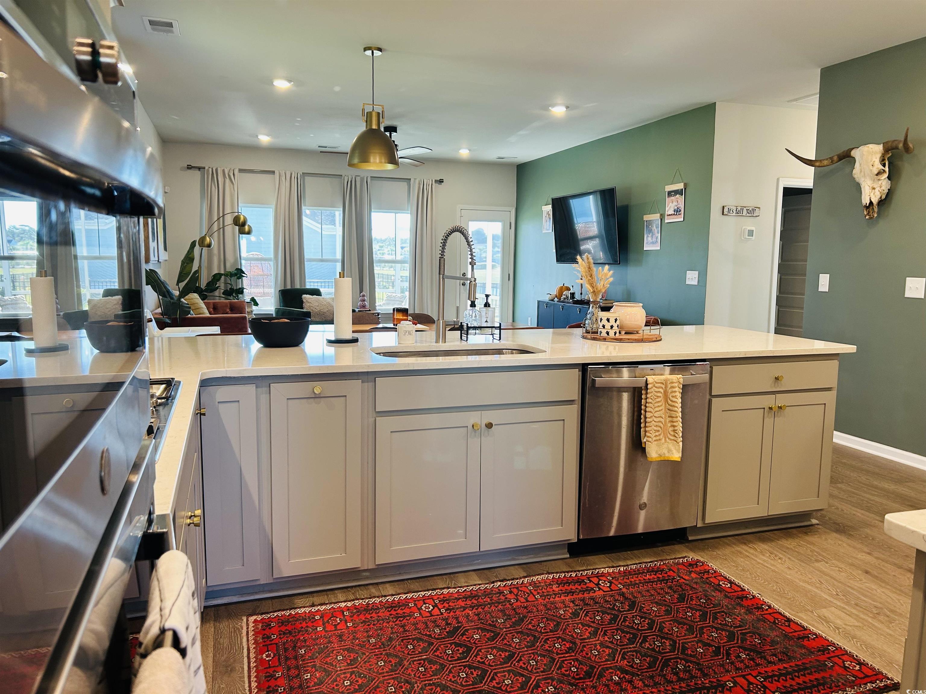 609 Shortleaf Path Myrtle Beach, SC 29577 - Photo 40 of 40 Kitchen with open floor plan, extractor fan, light wood-style flooring, dishwasher, and light stone counters