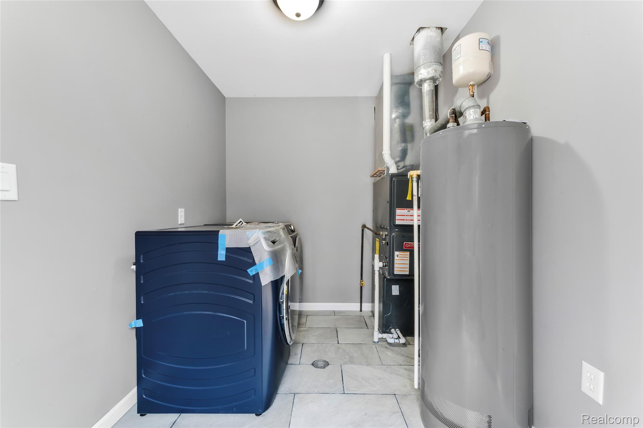 13515 Lenmoore Road Belleville, MI 48111 - Photo 15 of 41 Laundry area featuring washer / clothes dryer, water heater, light tile patterned floors, and heating unit