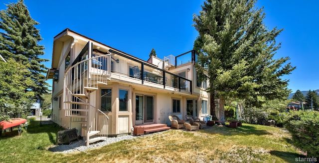a view of a house with a yard patio and fire pit