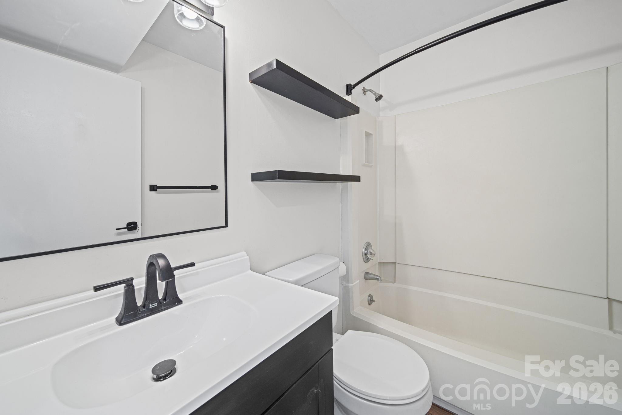 11023 Harrowfield Road Charlotte, NC 28226 - Photo 27 of 32 a bathroom with a bathtub shower sink vanity mirror and toilet