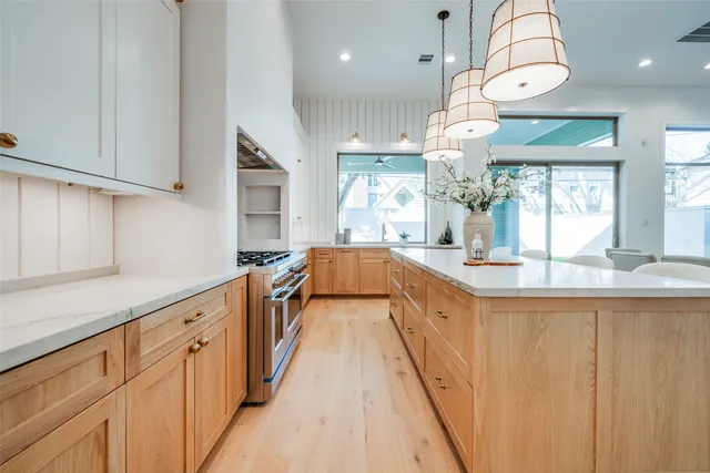 a kitchen with stainless steel appliances granite countertop a sink and a wooden floors