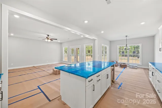 a kitchen with stainless steel appliances kitchen island granite countertop a sink and a refrigerator