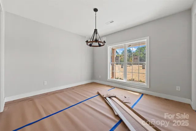 a room with a chandelier and a dresser