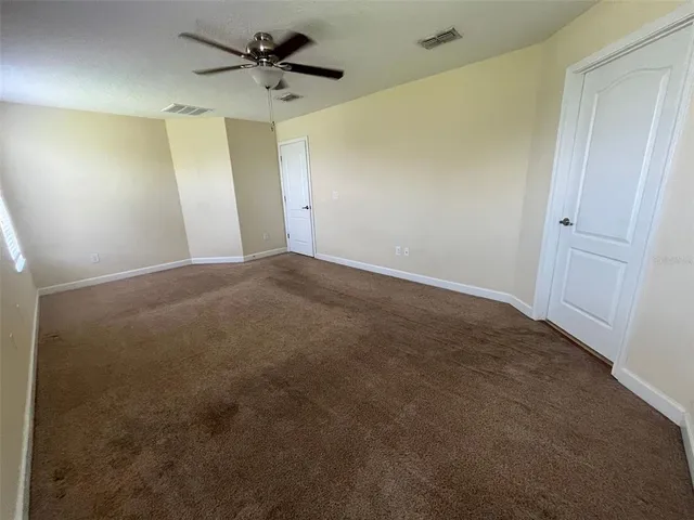 a view of a room with a ceiling fan and a window
