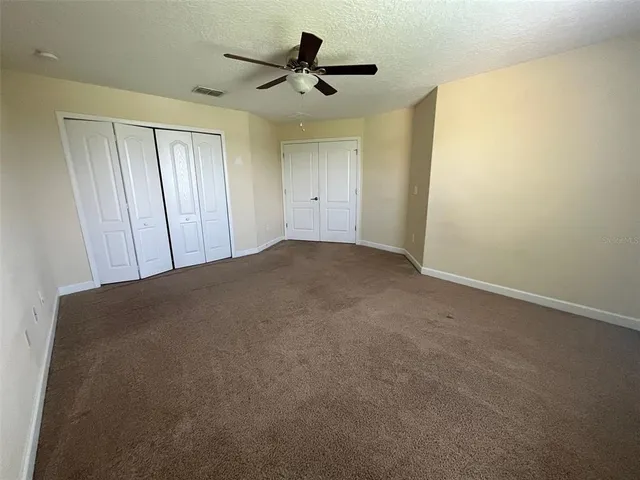 an empty room with a ceiling fan and a window