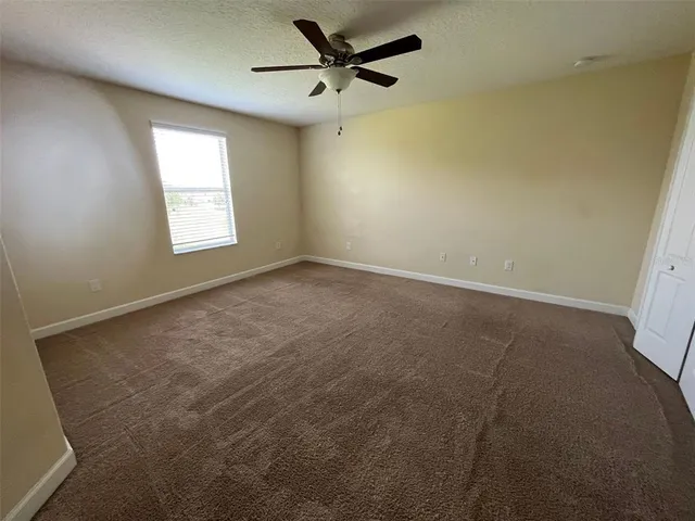 an empty room with a window and a fan