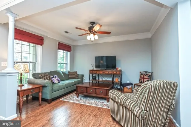 a living room with furniture a ceiling fan a fireplace and a window