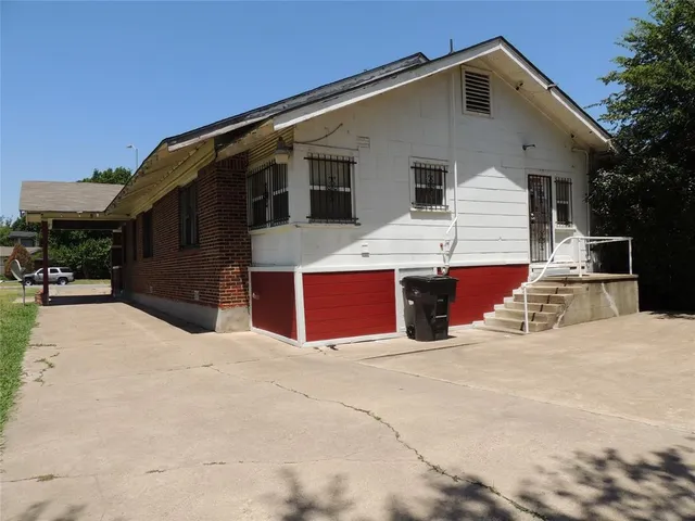 a view of house with yard and parking