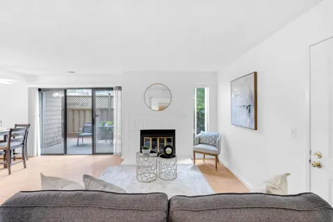 a living room with furniture a fireplace and a large window