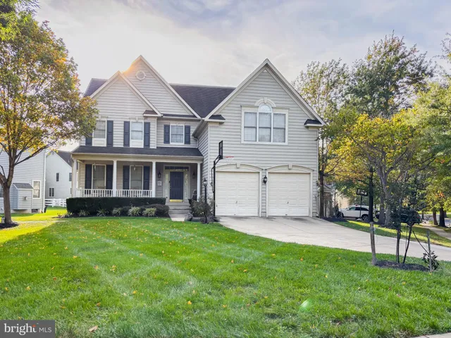 a view of a yard in front of a house with large trees