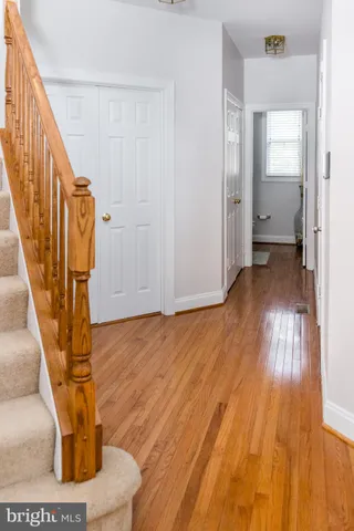a view of staircase with lots of frames on wall and wooden floor