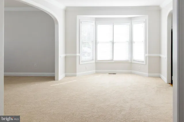 an empty room with windows and mirror