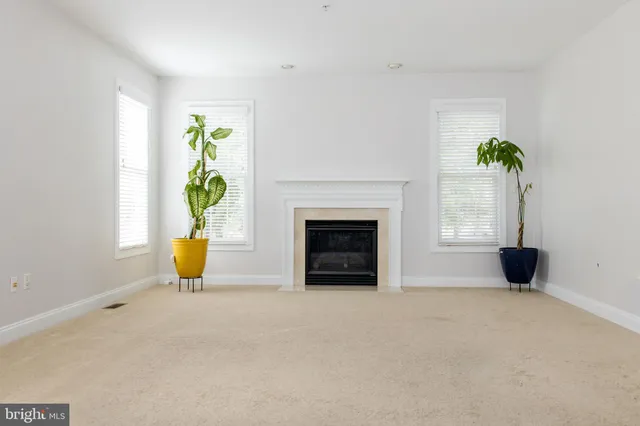 a view of an empty room with fireplace and stairs