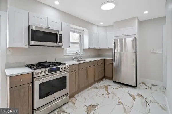 a kitchen with stainless steel appliances granite countertop a stove a sink and a microwave