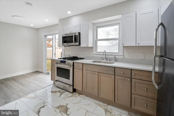 a kitchen with a refrigerator and a stove top oven
