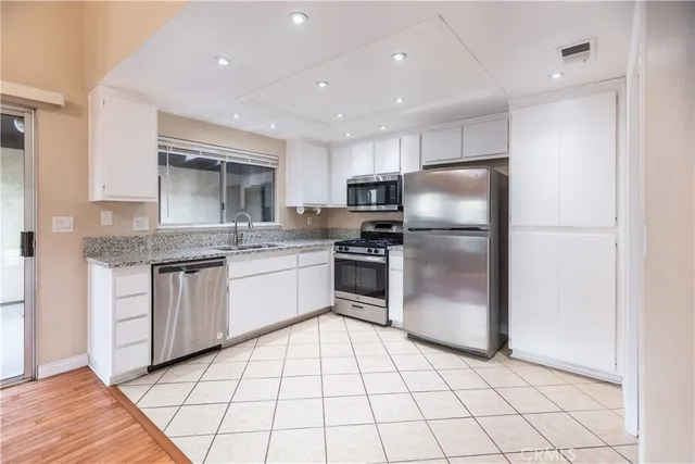 a kitchen with a refrigerator sink and cabinets