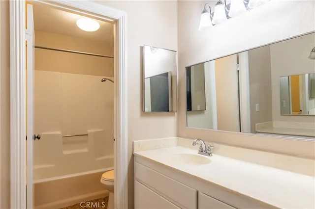 a bathroom with a granite countertop sink mirror and a shower