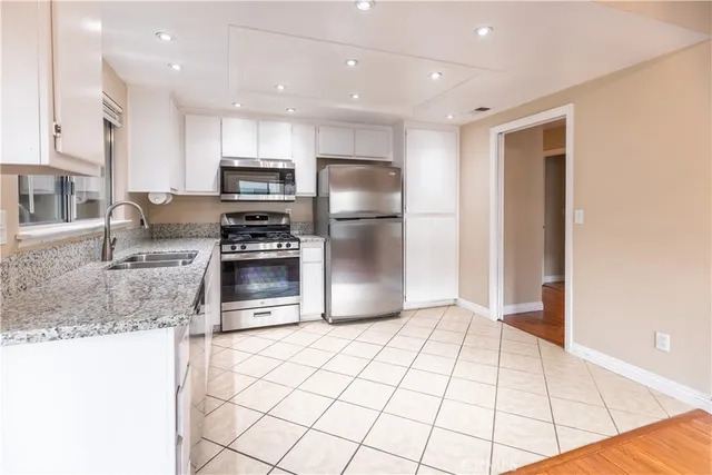 a kitchen with granite countertop a refrigerator and a sink