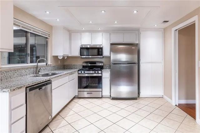 a kitchen with stainless steel appliances granite countertop a refrigerator a sink a stove a microwave and island