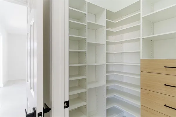 a living room with stainless steel appliances furniture a chandelier and a view of kitchen