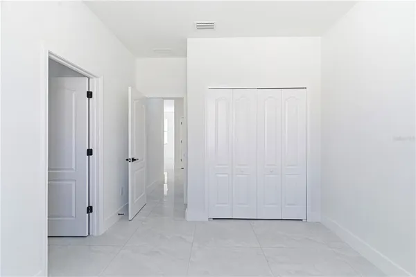 an empty room with windows and ceiling fan