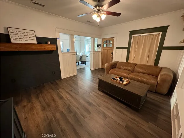 a view of a dining room with furniture a chandelier and wooden floor