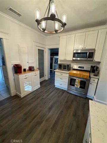 a view of a livingroom with wooden floor and furniture