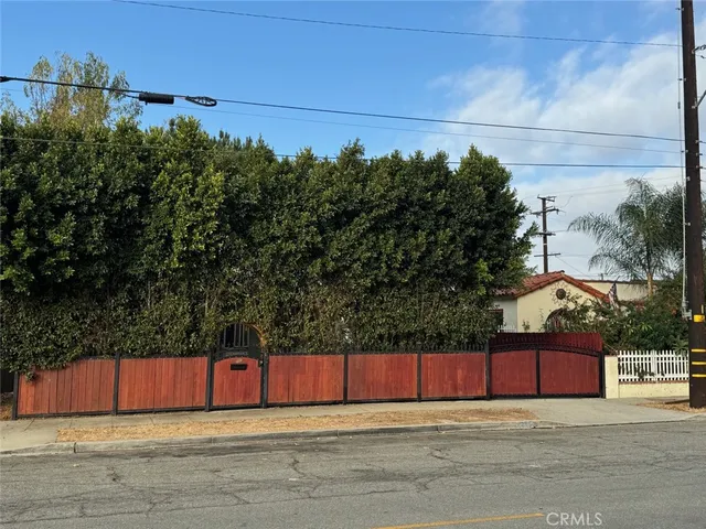a view of a yard with wooden fence