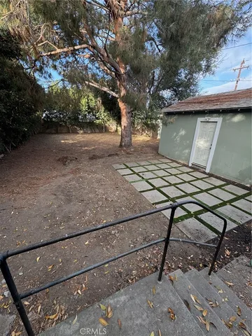 a view of a house with a large tree and a yard