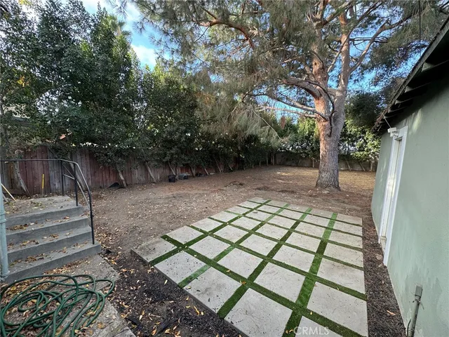 a view of dirt yard with large trees