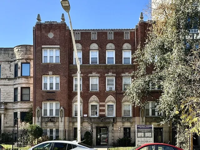 a front view of a residential apartment building with a yard