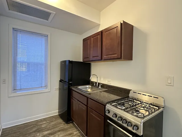 a kitchen with wooden cabinets and a stove top oven