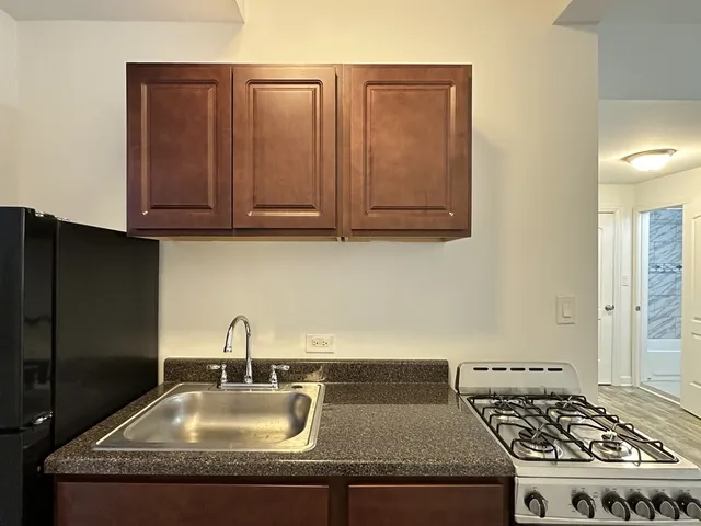 a kitchen with granite countertop a sink stainless steel appliances and cabinets