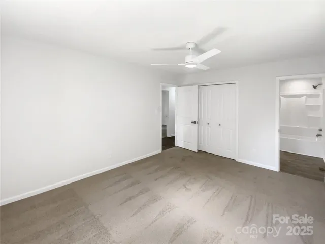 an empty room with an entryway and fan