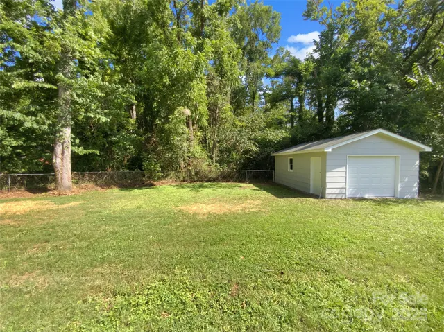 a house is sitting in middle of the green field