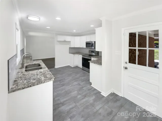 a kitchen with stainless steel appliances granite countertop a sink and a stove