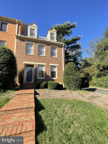 a front view of a house with a yard and potted plants
